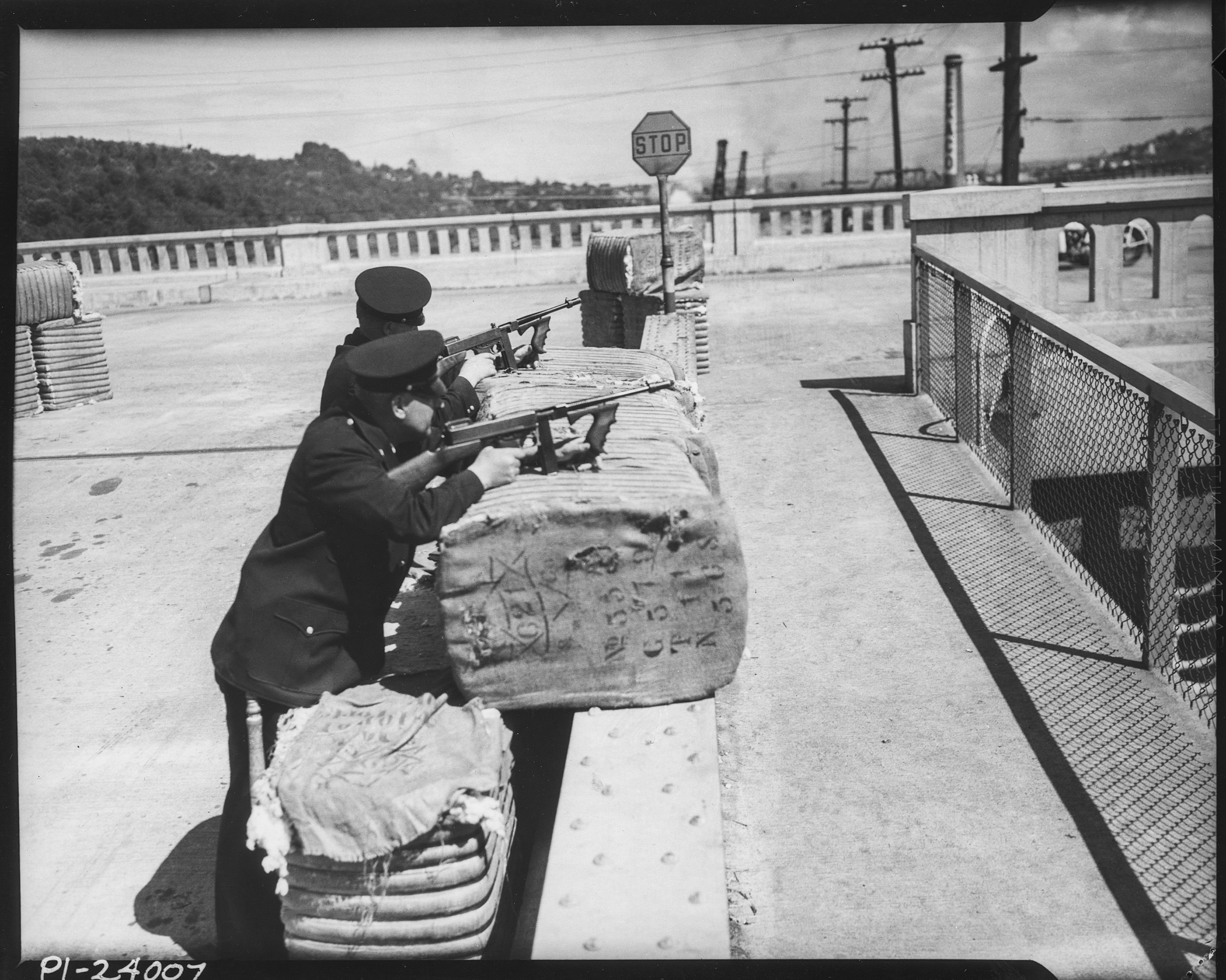 two policemen behind bales, black and white