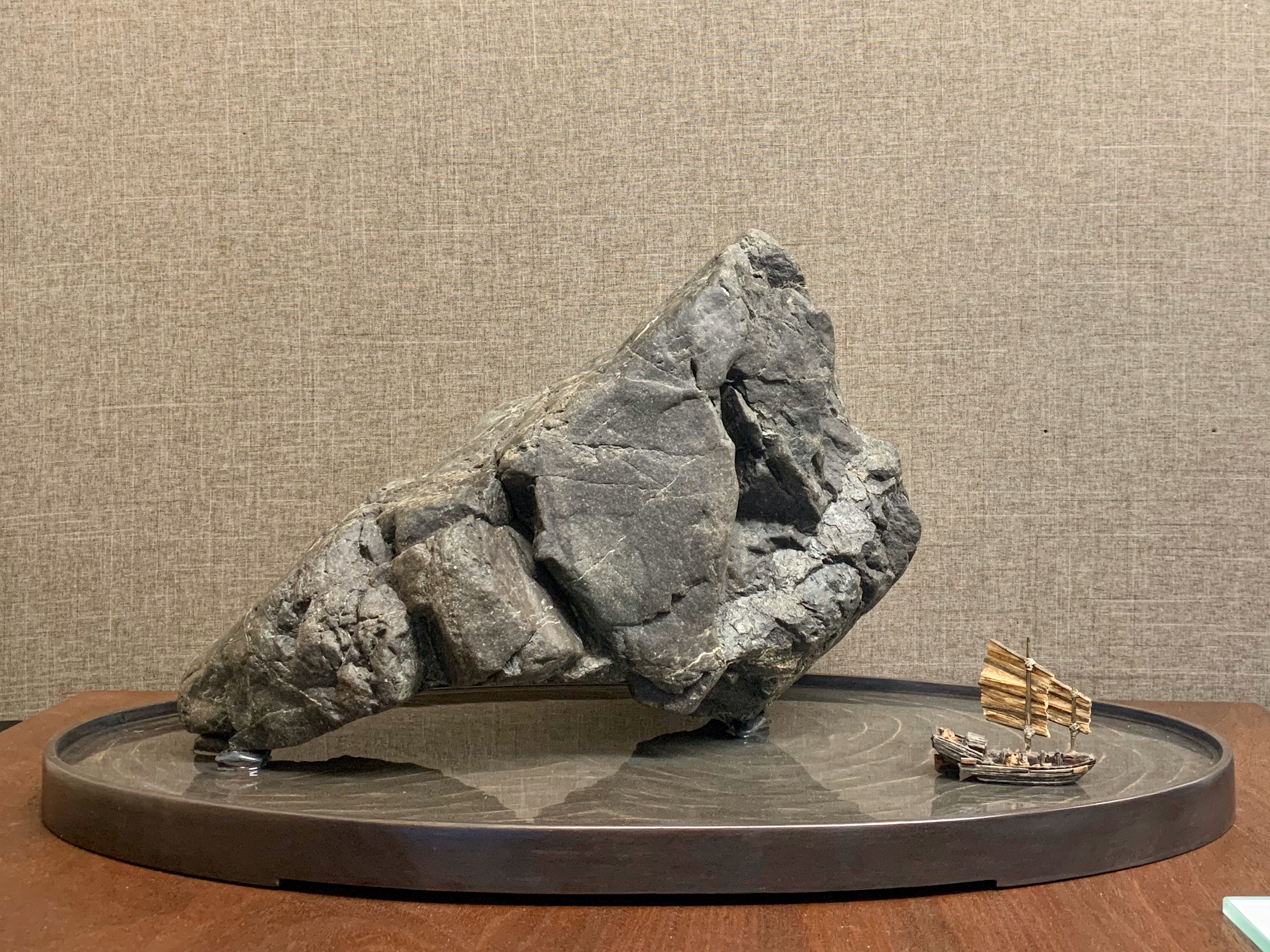 a decorative rock with a tiny boat in front of it