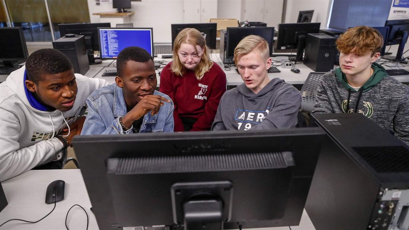 Students gather around a computer