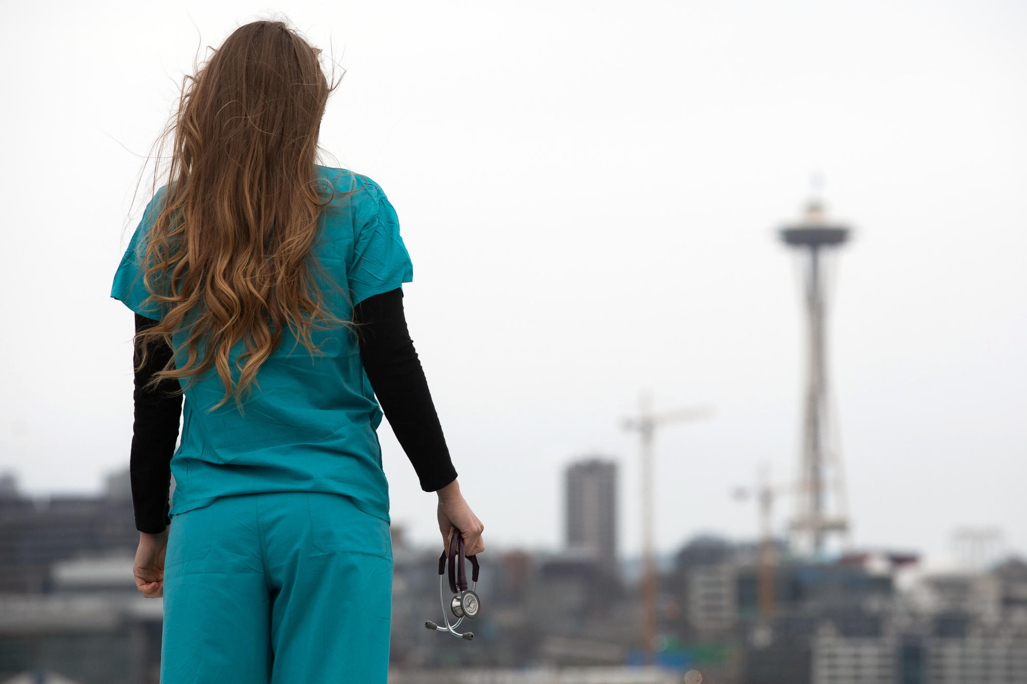 Nurse stands looking at Space Needle