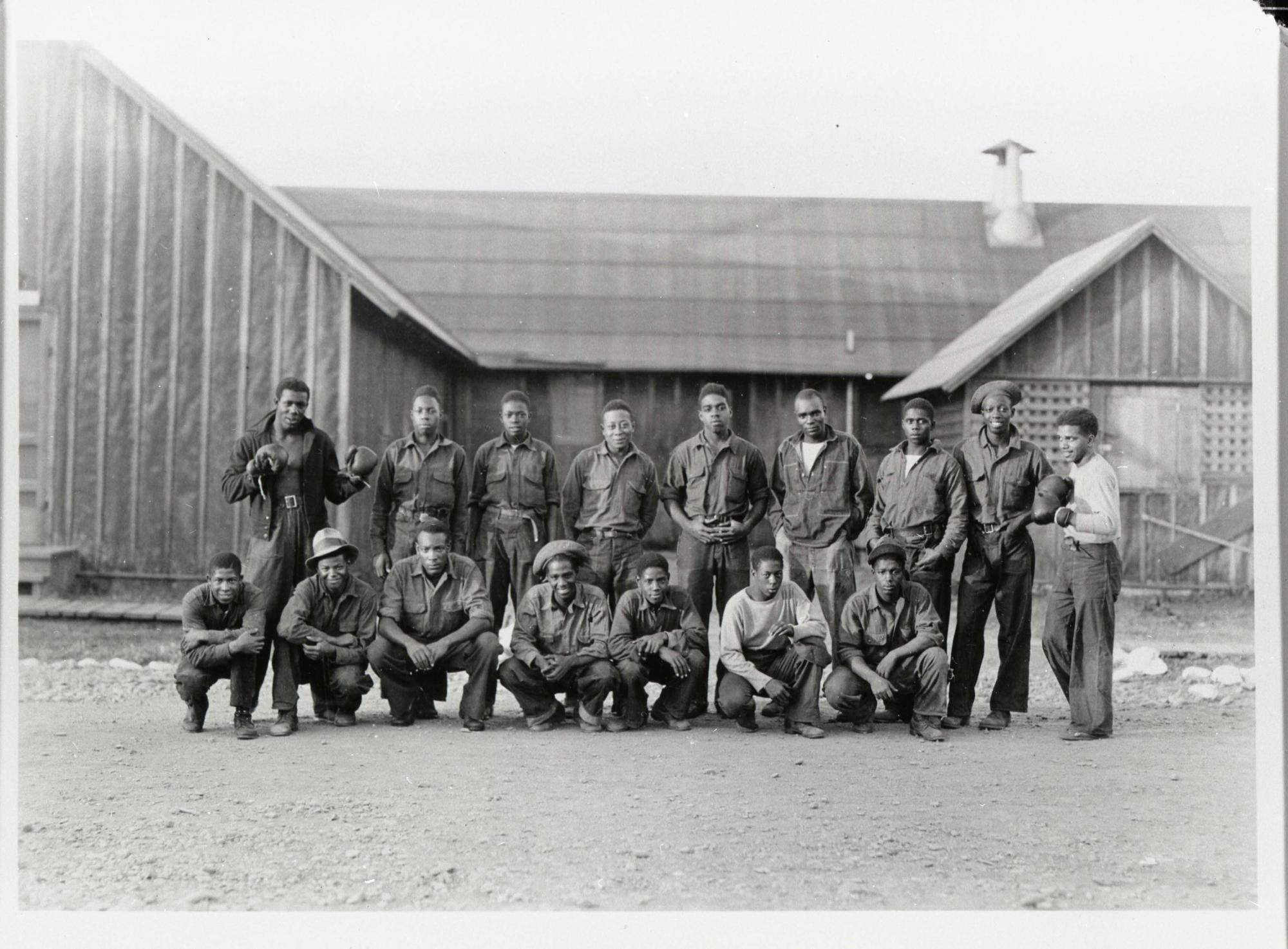 Archival image of a group of men posing in front of a building