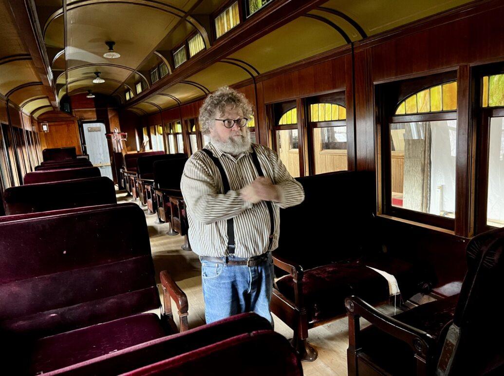 Knute Berger stands inside a vintage train car
