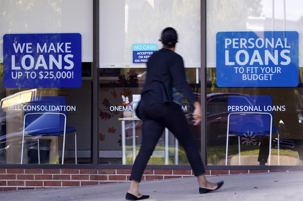 Person walking in front of loan signs