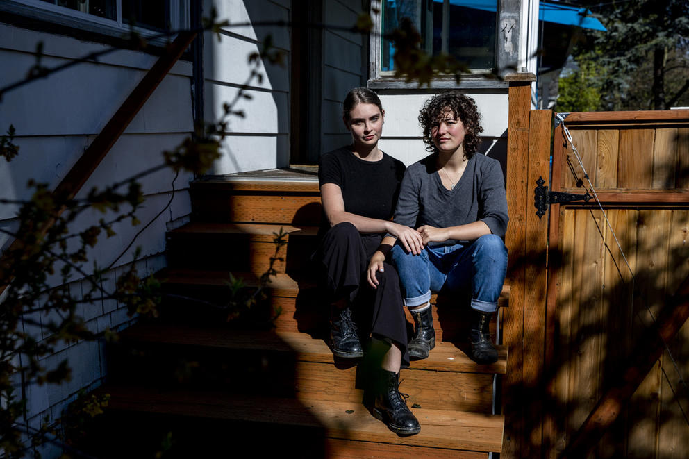 Two people sitting on a sun-lit front porch