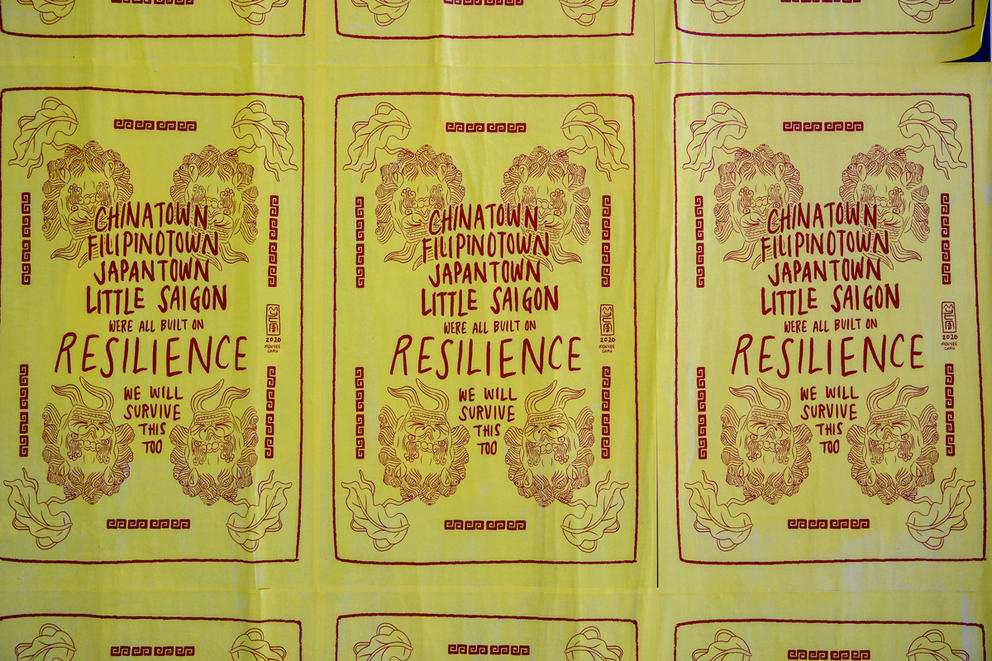 Yellow poster with red text stating:“Chinatown, Filipinotown, Japantown, Little Saigon were all built on resilience. We will survive this, too.” 