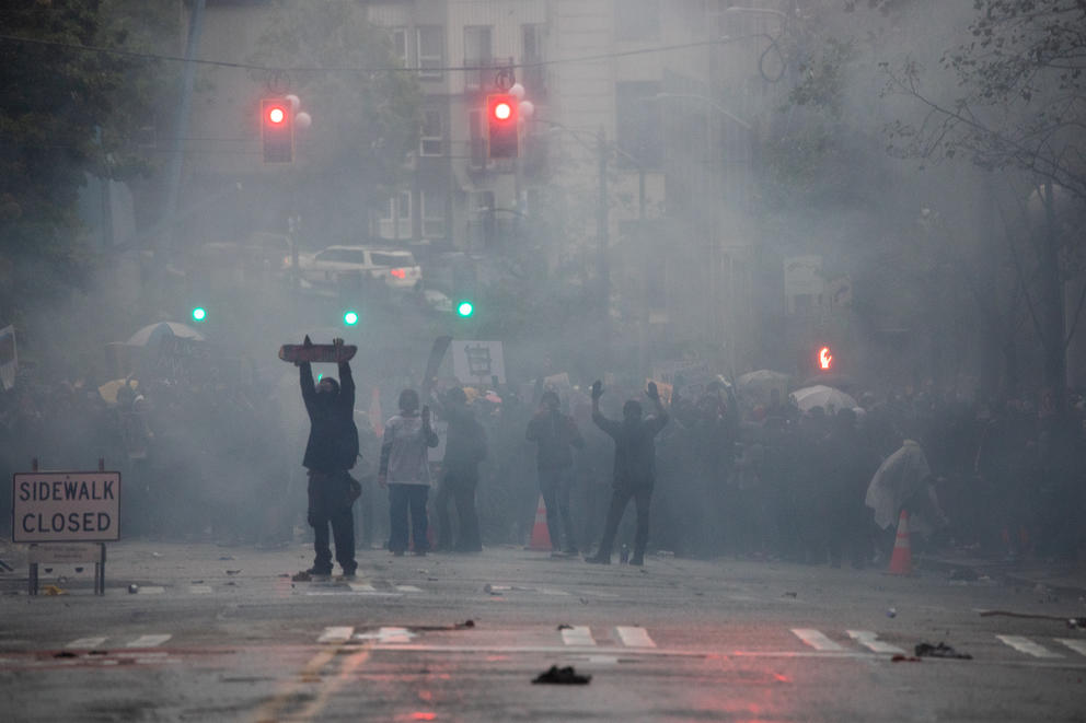 Demonstrators stand amid a cloud of tear gas. 