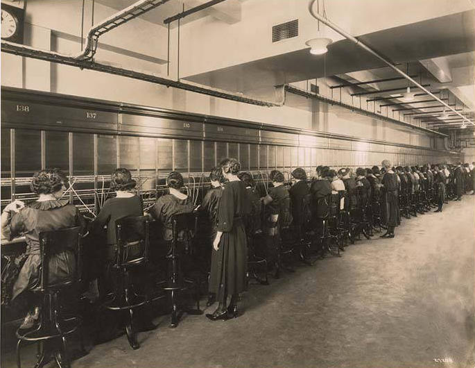 Women lined up serving as telephone operators, sepia tone image
