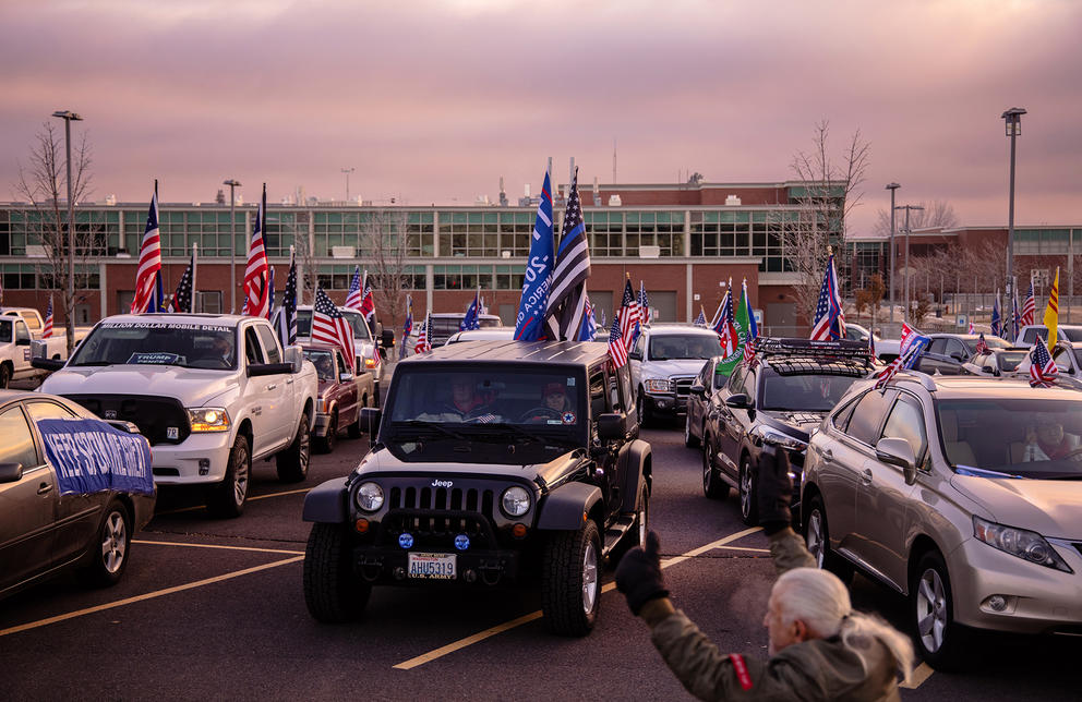 Vehicles in a parking lot with Trump flags