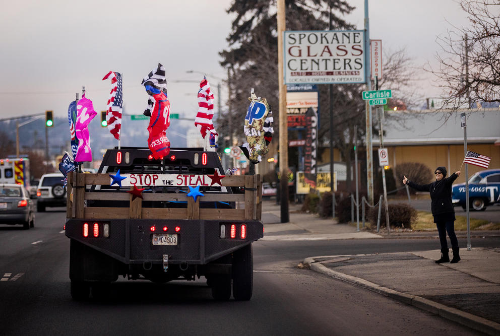 A truck drives down a street with Trump flags
