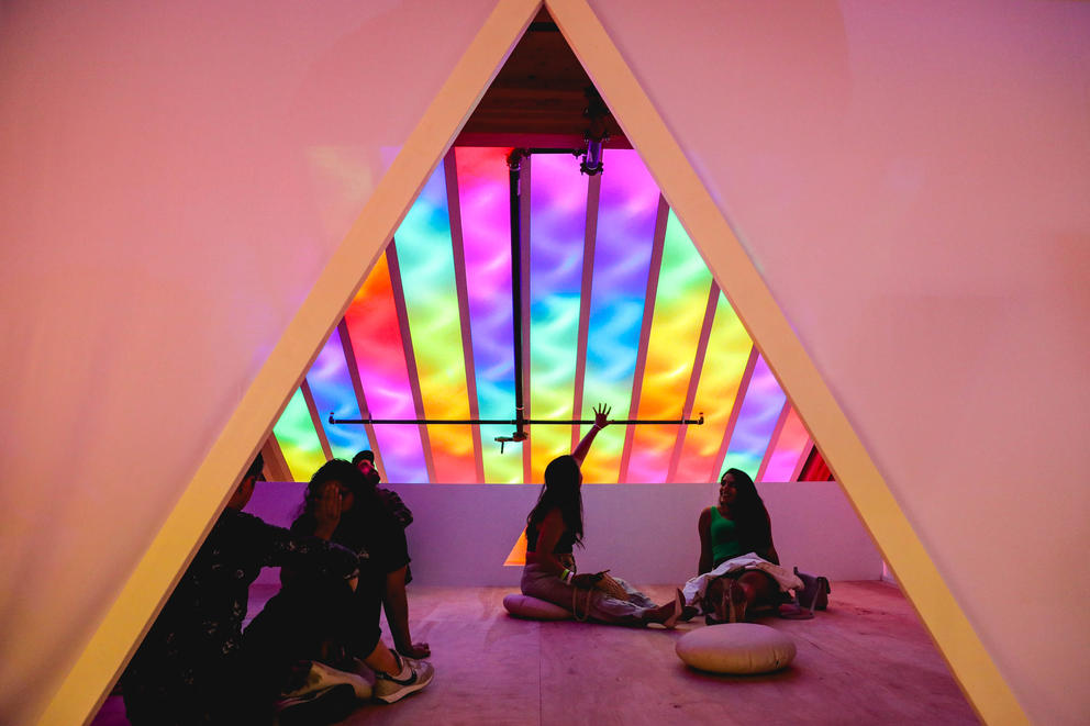 photo of an A-shaped opening in a wall featuring a view into a rainbow-lit room
