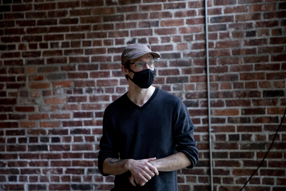 person with black mask in front of brick wall