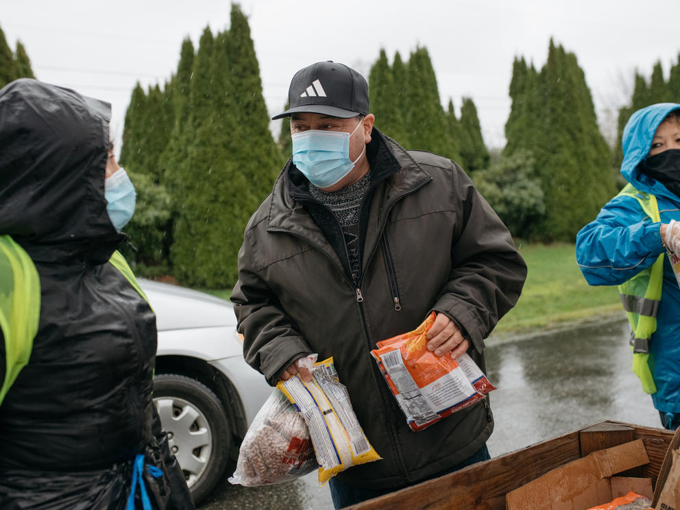 Volunteers handing out food while wearing face masks
