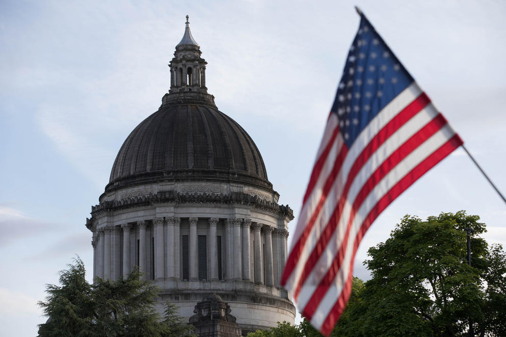 WA state Capitol dome with flag flying in foreground