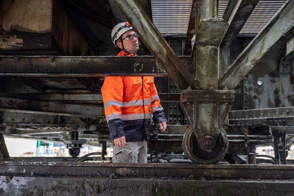WSDOT employee Colt Tatum stands behind steel girders beneath the Heron Street Bridge.