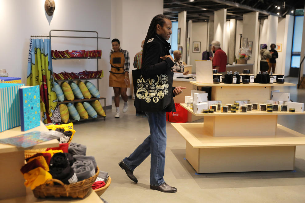 a man carries a tote bag through a retail shop