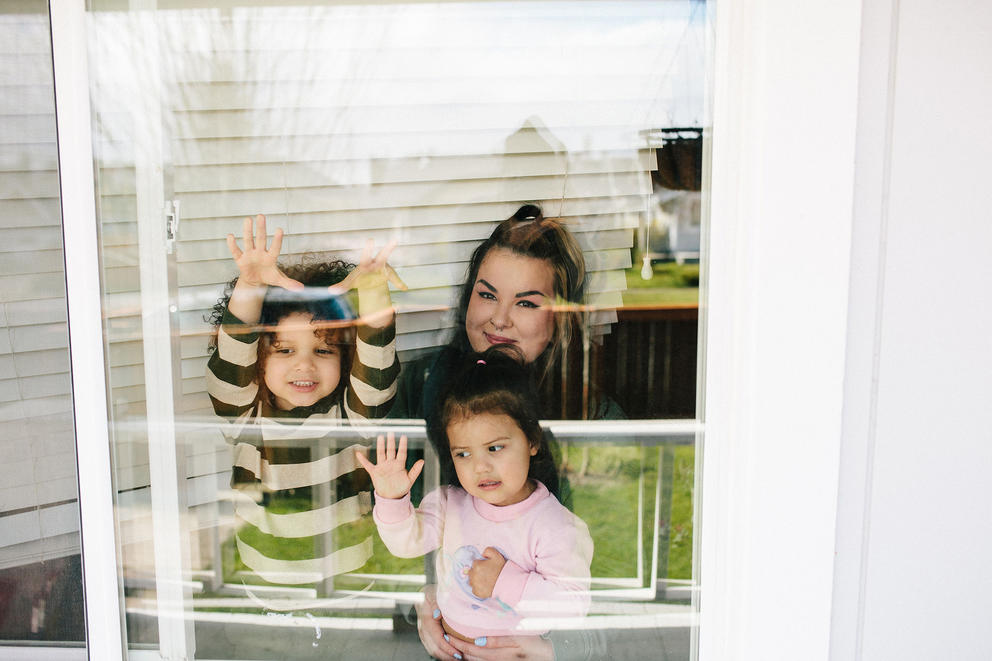 Mother with two children behind glass window