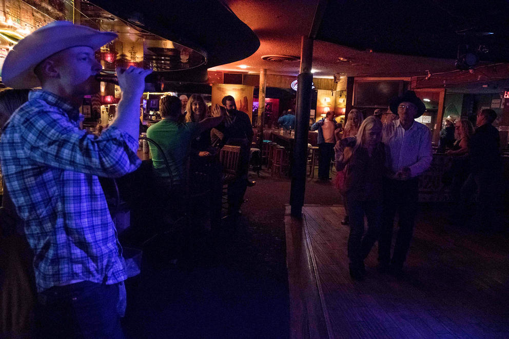 A man swills his beer while other dance on a recent night at Little Red Hen 