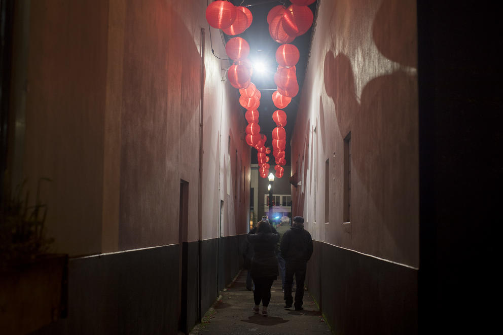 People walk through a decorated alley near Fort George Brewing during Fisher Poets Gathering in Astoria.