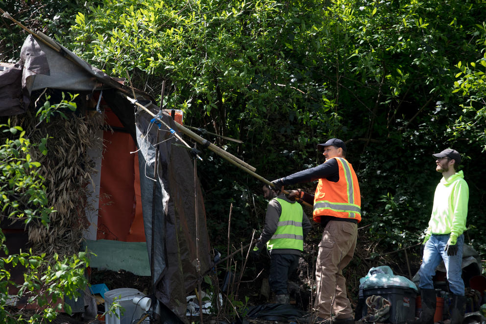 City workers remove a structure during a sweep of Ravenna Woods homeless encampment near Seattle's University Village neighborhood, Tuesday, April 17.