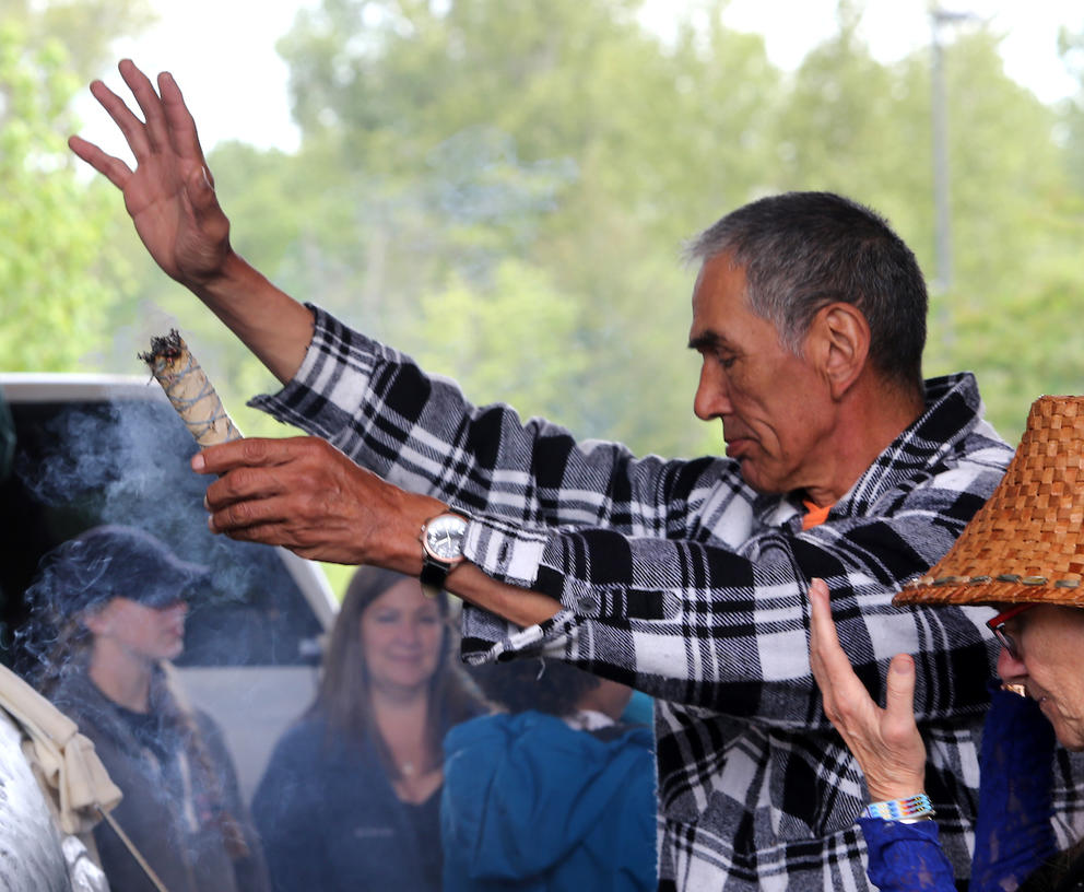 A member of the Lummi tribe burns sage during a blessing and naming ceremony for a 16 foot totem pole in the shape of a whale and two dolphins held at the Lummi Tribal Center for in Bellingham, WA on May 10, 2018. (Photo by Karen Ducey)