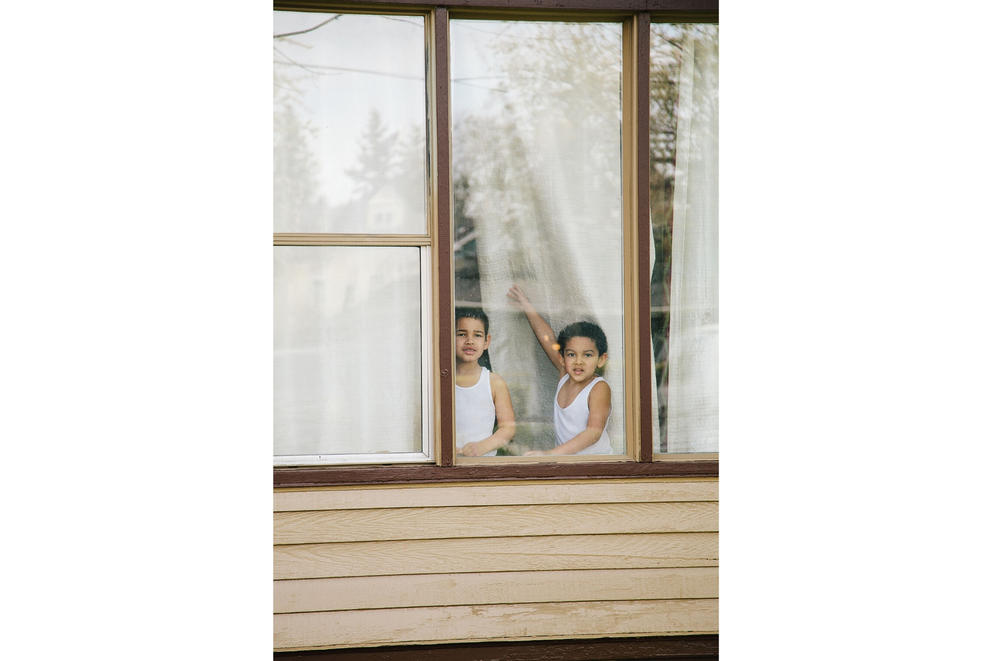 Two brothers in the window with white t-shirts