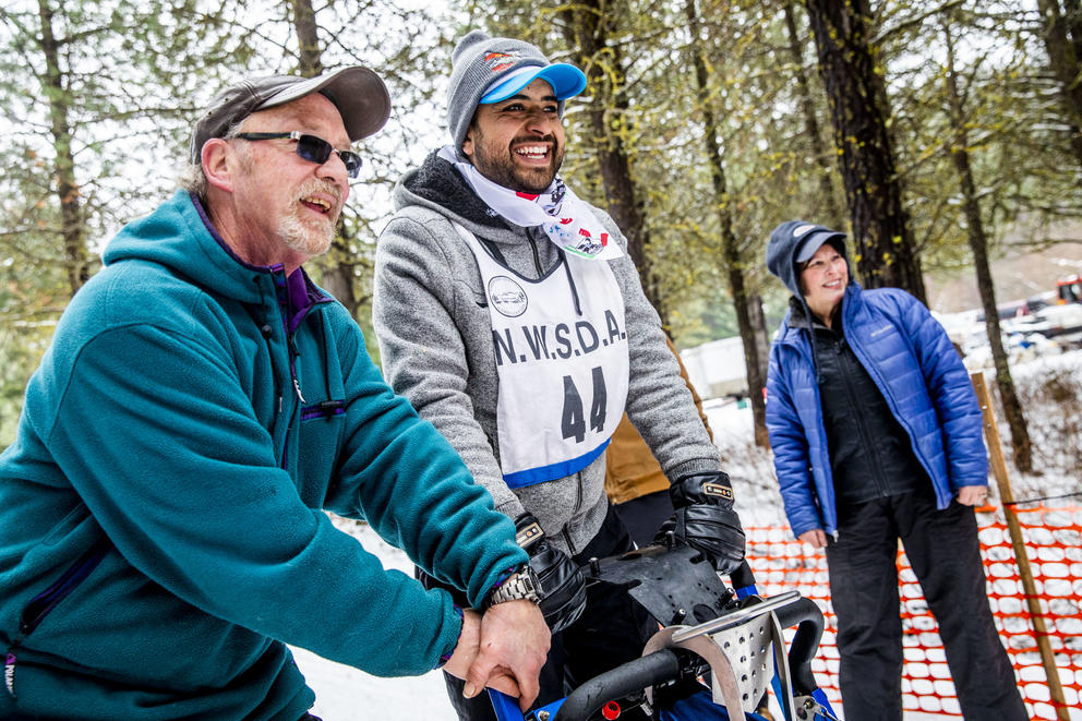 Larry Roxby, left, helps Marcos Padilla get lined up at the start line before his race in the Northwest Sled Dog Association Dogtown Winter Derby at Camp Koinonia in Cle Elum on Saturday, Jan. 12, 2019. Padilla and two other dog sledders from Urban Mushing Leon in Mexico traveled to Washington to work with the Roxby family and their dogs and compete for the first time on snow. (Photo by Dorothy Edwards/Crosscut)