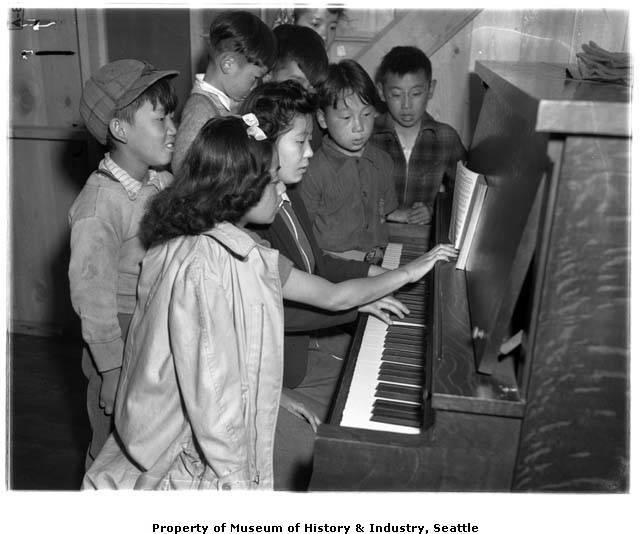 Teenage incarcerees gathered at a piano, Puyallup Assembly Center
