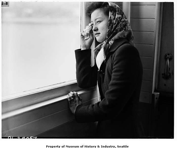 A Japanese American woman, 19-year-old Mrs. Sumiko Furuta, cries while looking out the ferry window after forced removal from Bainbridge Island