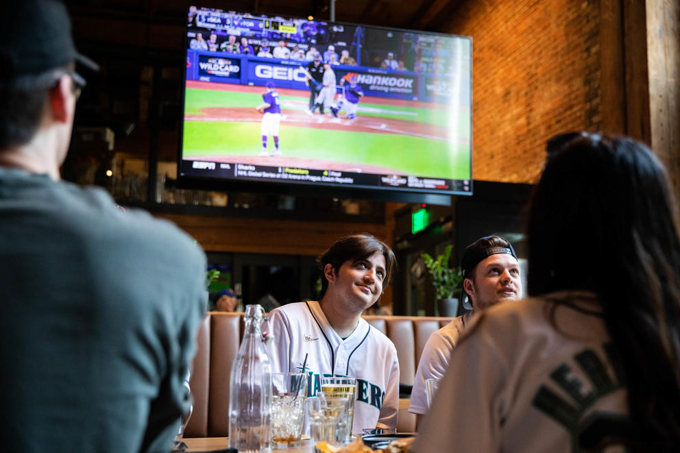 people watch a baseball game in a bar