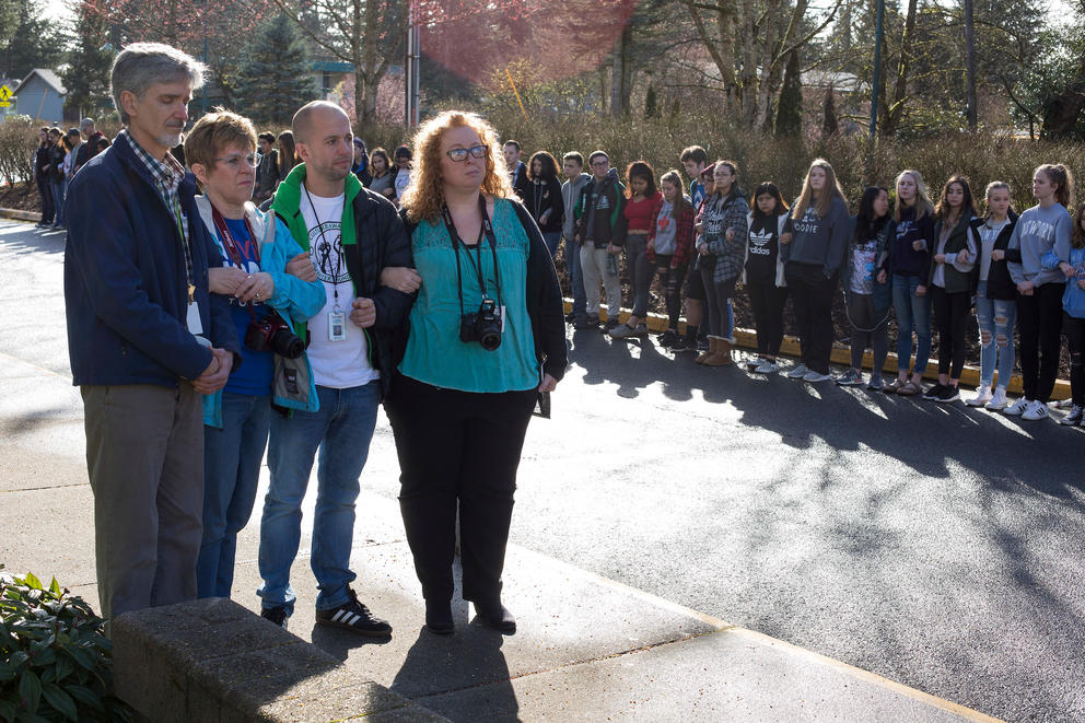 Students stand in a line and link arms for 17 minutes, honoring the 17 killed at a school shooting in Parkland, Florida