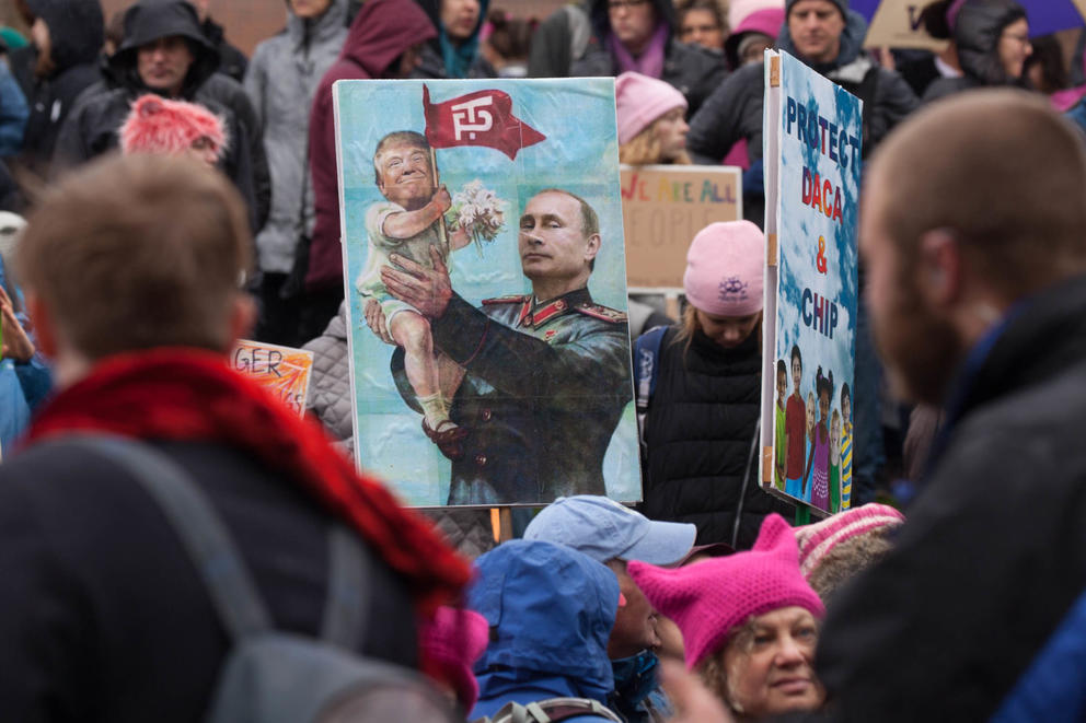 One sign in the crowd depicts President Donald Trump as Russian president Vladimir Putin’s baby during the Seattle Women’s March 2.0 in Seattle, Jan. 20, 2018.