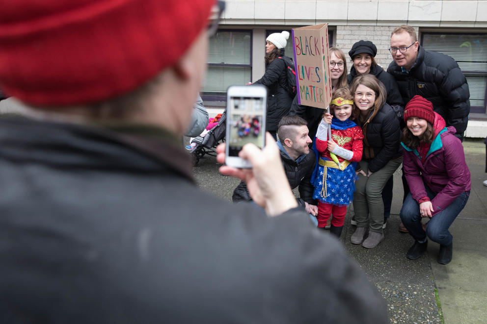 Protesters gathered for a photograph with a young girl dressed as Wonder Woman during the Seattle Women’s March 2.0 in Seattle, Jan. 20, 2018.