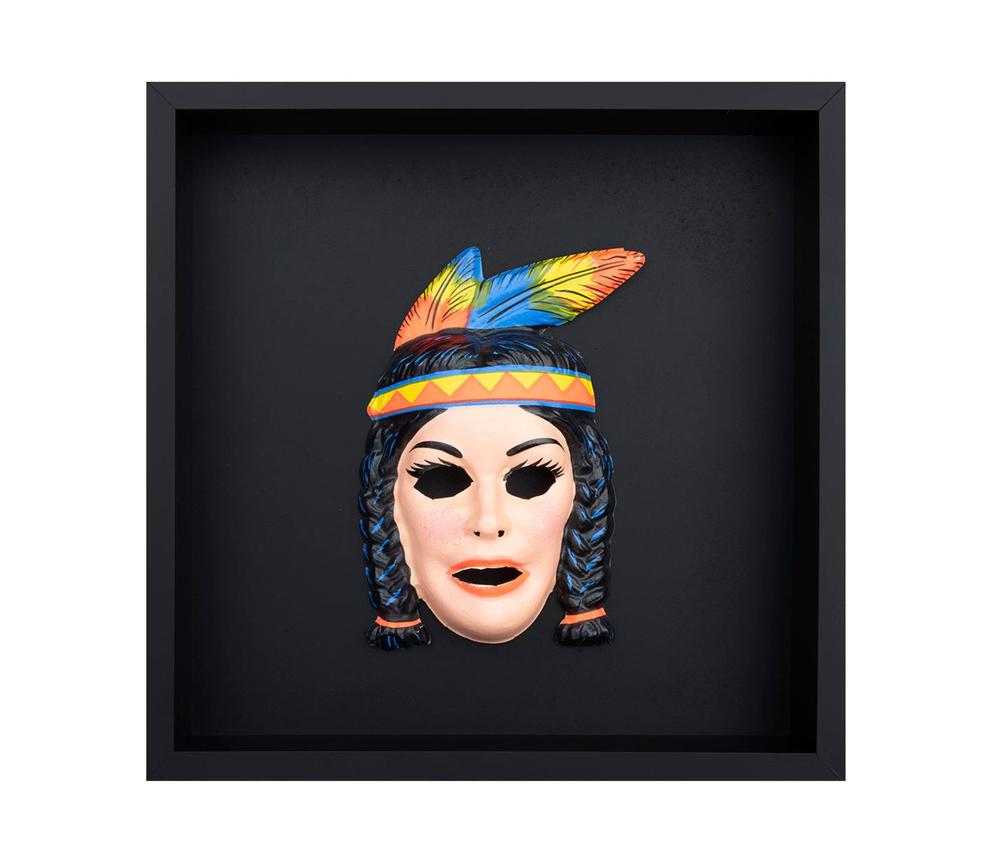 plastic mask of a woman with black braids and colorful feathers