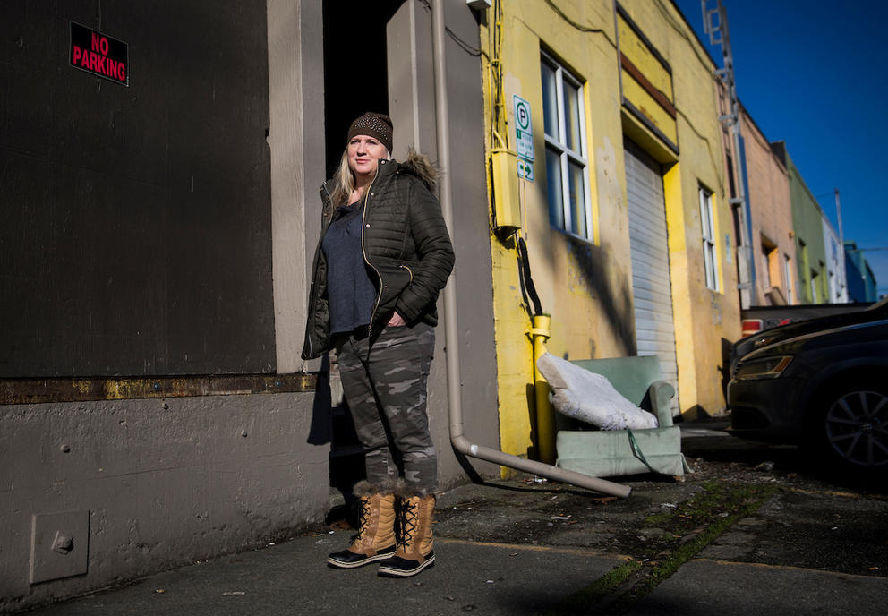 Jodi Opitz, owner of Seattle Rehearsal, stands for a portrait in front of a “no parking” sign she keeps up on her building to make sure her business is accessible to herself and her customers 24/7 on Occidental Avenue South in Seattle's SODO neighborhood