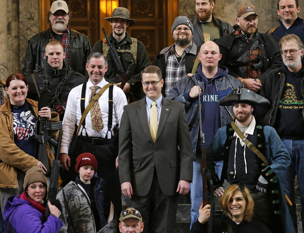Matt Shea stands in the House gallery, surrounding by people open-carrying firearms.