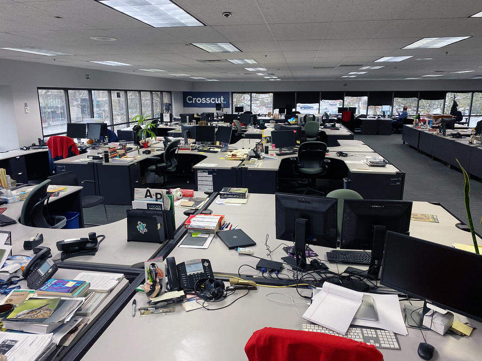 Empty chairs and desks inside Crosscut's newsroom