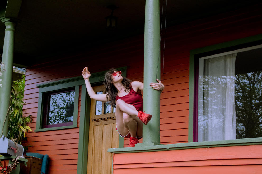 Woman in red outfit and red shoes on her porch, dancing