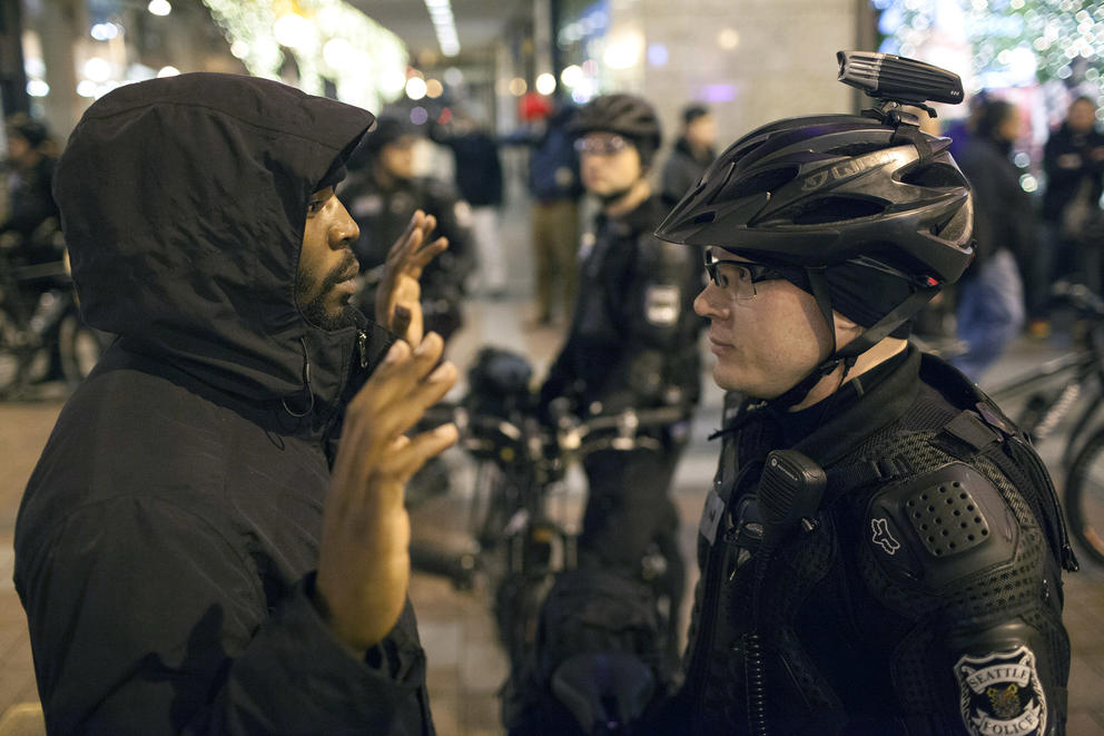 A black man face to face with a white male police officer