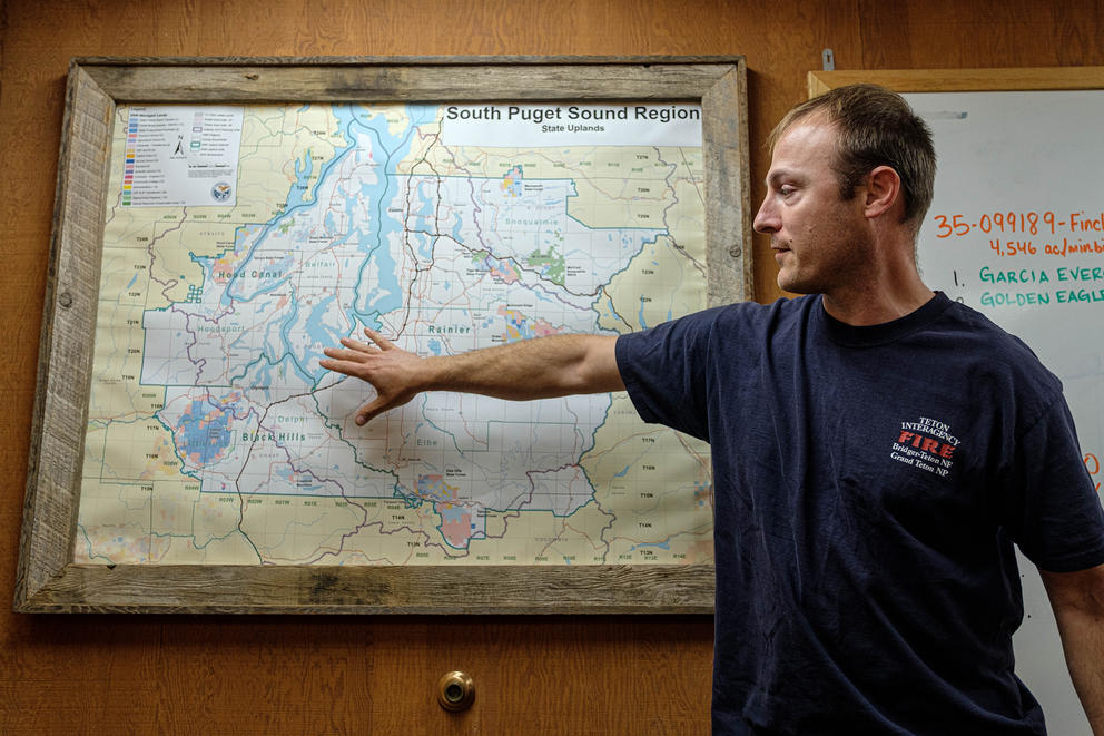 A firefighter references an area on a map