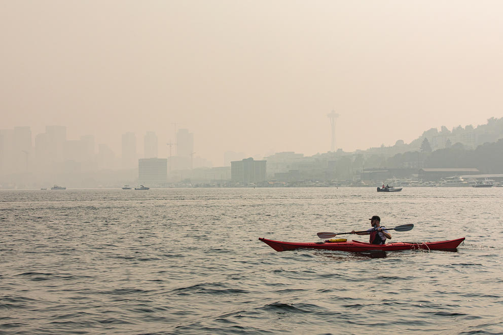 A kayaker paddles across Lake Union through wildfire smoke that obscures the Seattle skyline, September 11, 2020. (Dan DeLong/InvestigateWest)