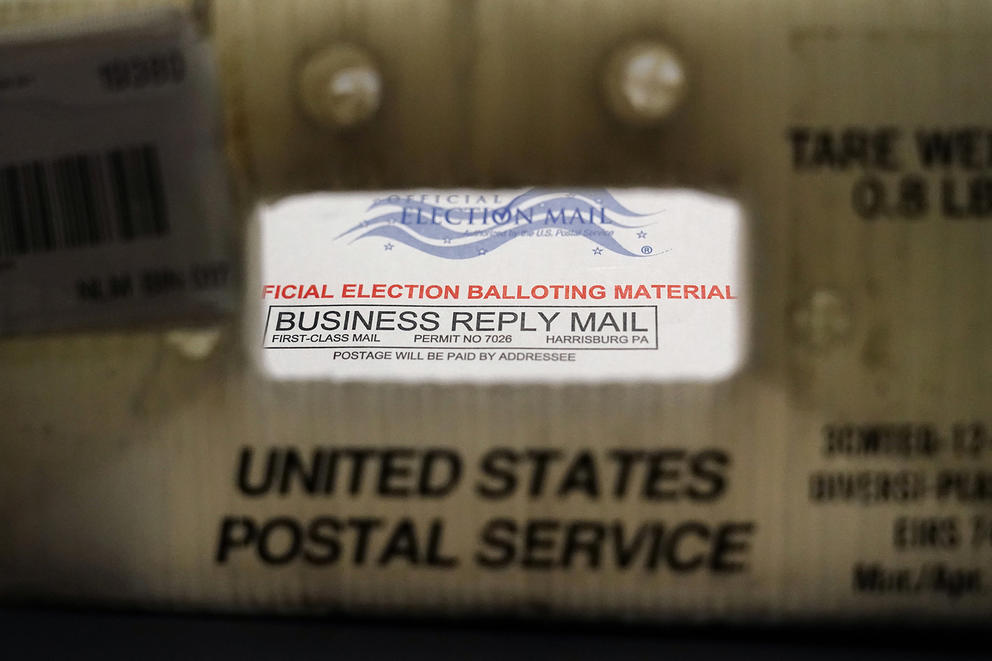 A ballot peeks through a plastic post office basket