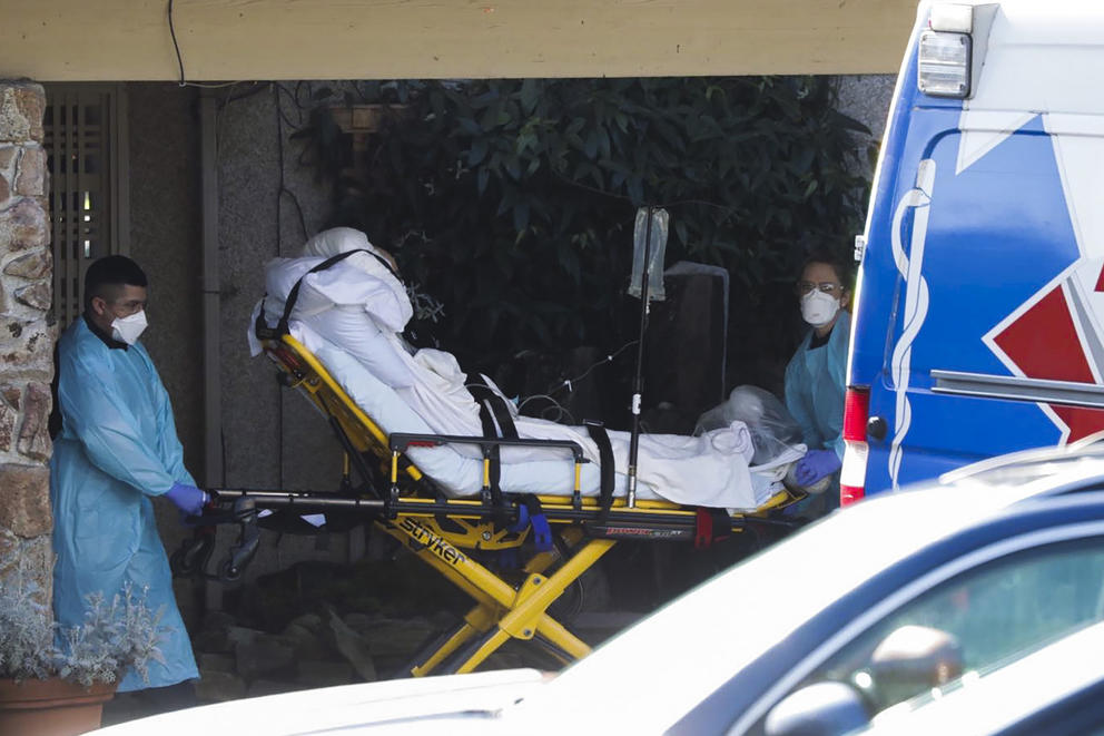 body on gurney pushed by medical workers