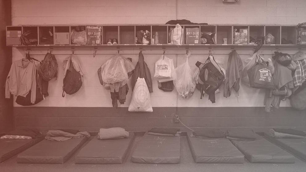 mats and bags lined up at a homeless shelter