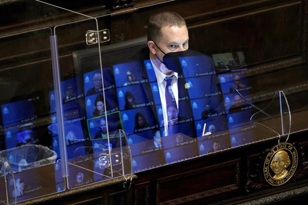 A man in a mask with screens in front of him during 2021 virtual legislative session