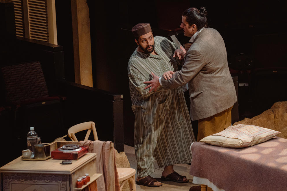 two men struggle on stage, one in middle-eastern clothing