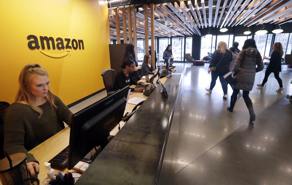People walk by the front desk at an Amazon office. 