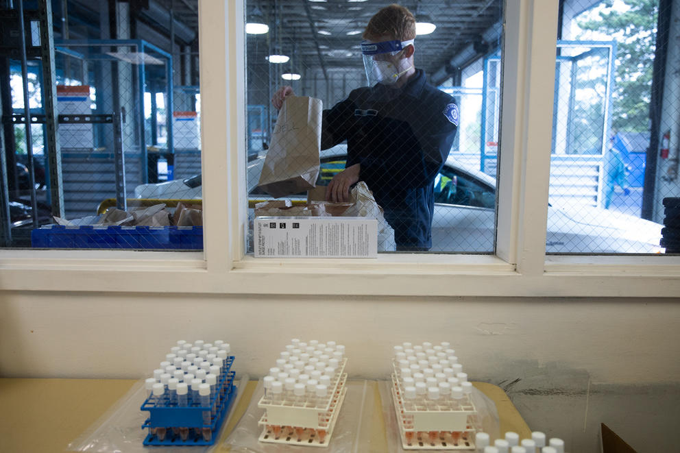 Workers prep materials at a drive-up COVID-19 testing facility