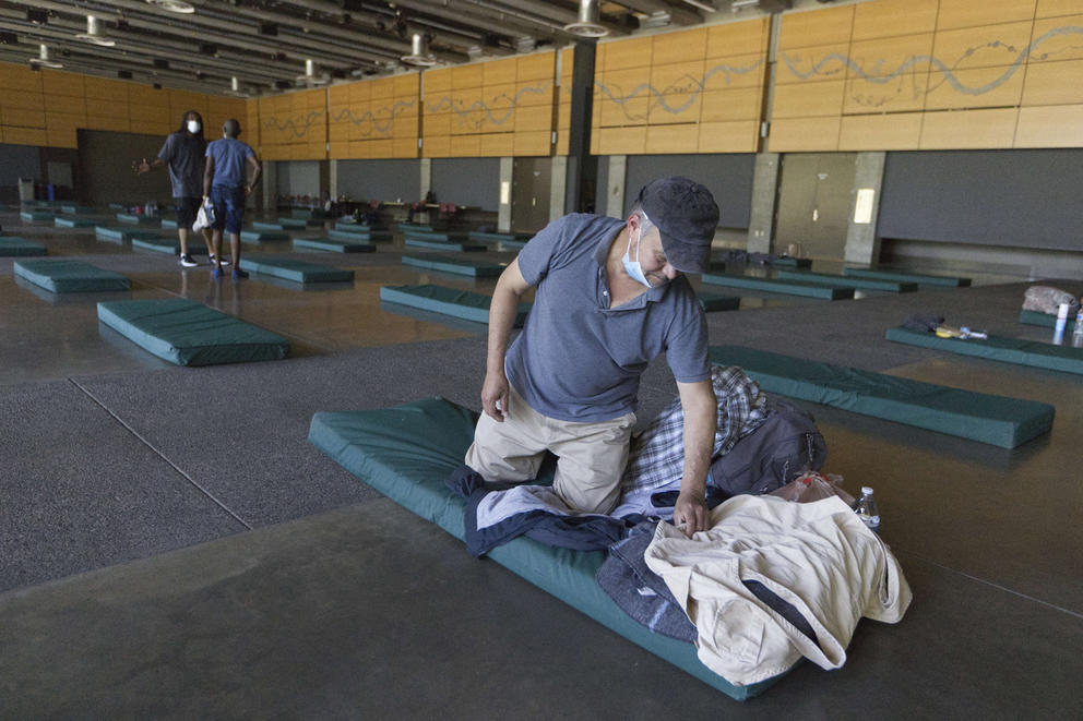 Roberto Cedomio prepares his bed at a cooling shelter run by the Salvation Army at the Seattle Center