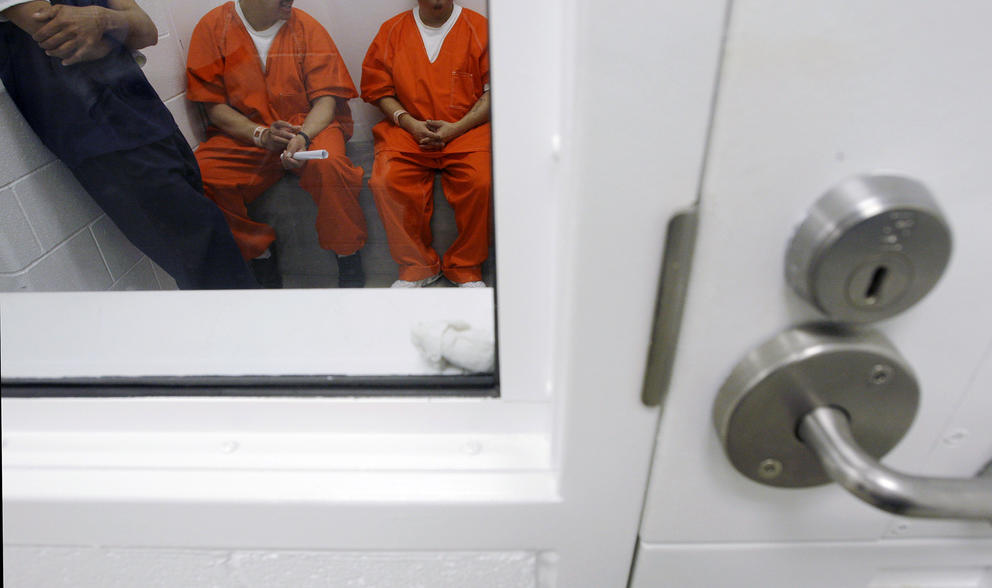 men in a detention center cell