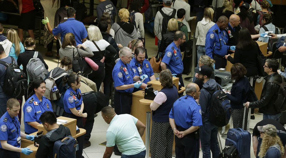 TSA agents check passenger boarding passes and identification at a security screening checkpoint, Thursday, May 19, 2016, at Seattle-Tacoma International Airport in Seattle. Airport officials announced Thursday that following a training period, several dozen contract employees will start work on Monday, May 23, 2016 to assist passengers at security checkpoints, with the goal of freeing up TSA agents and reducing passenger wait times. (AP Photo/Ted S. Warren)